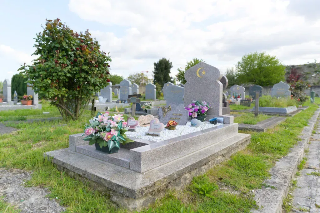Tombe musulmane ornée de fleurs dans un cimetière