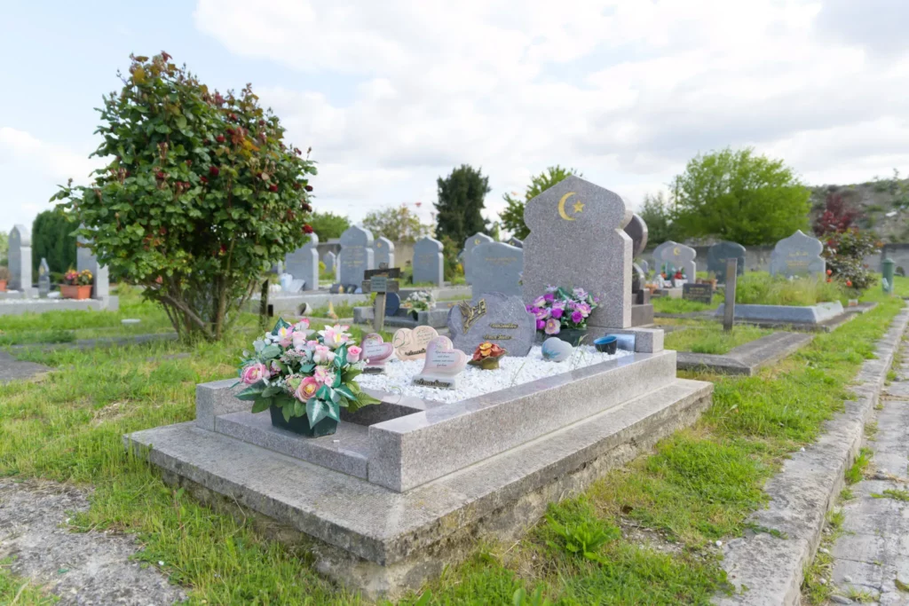 Monument funéraire musulman en granit rose orné d'un croissant doré et de fleurs