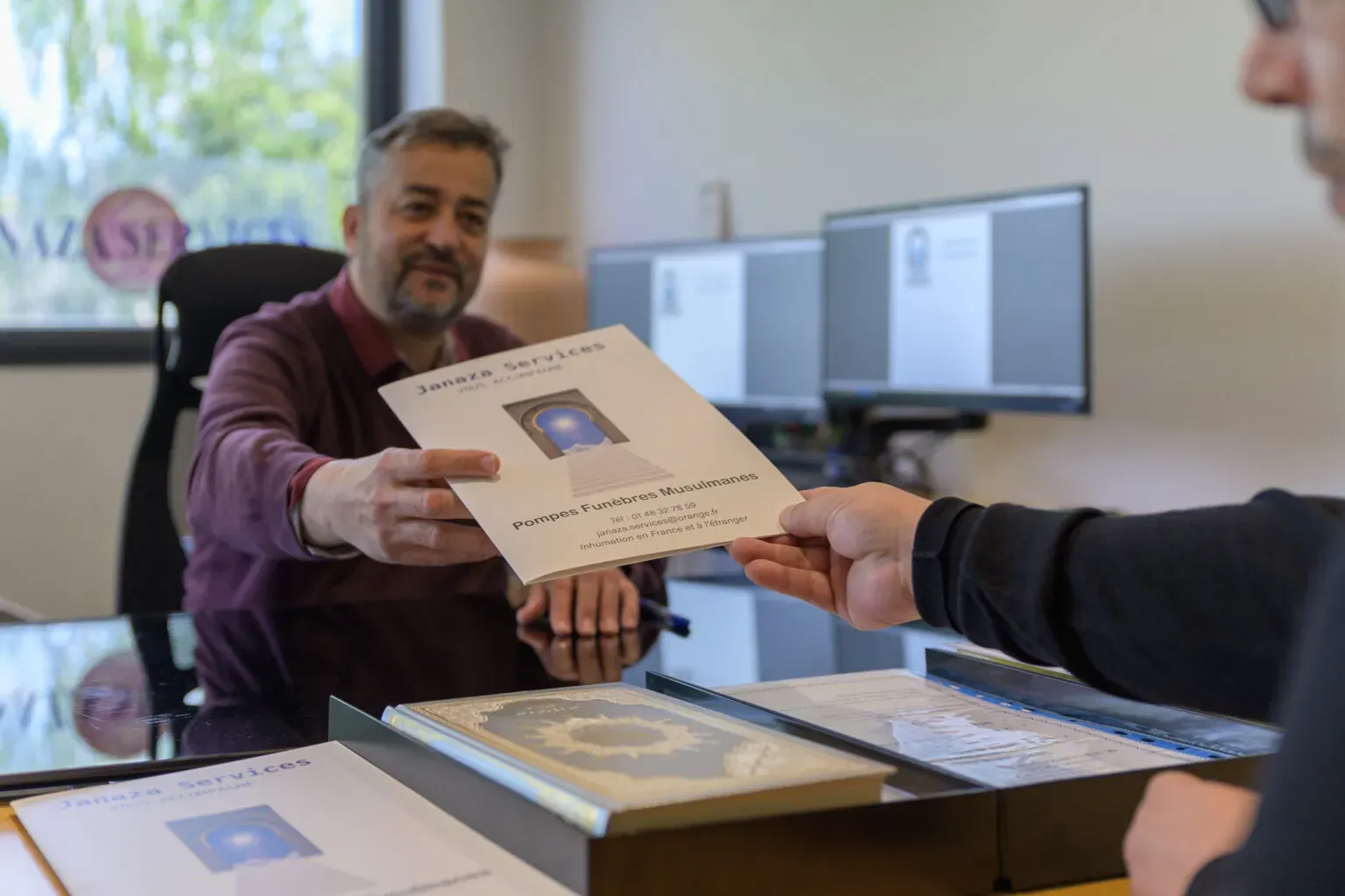 Conseiller en pompes funèbres musulmanes remettant une brochure d'accompagnement à une famille